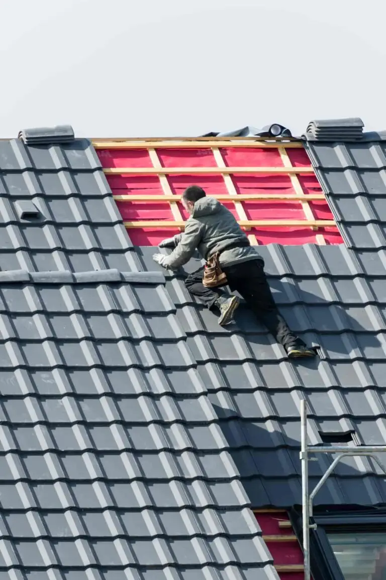 Travailleur installant des tuiles lors de l'isolation d'une toiture