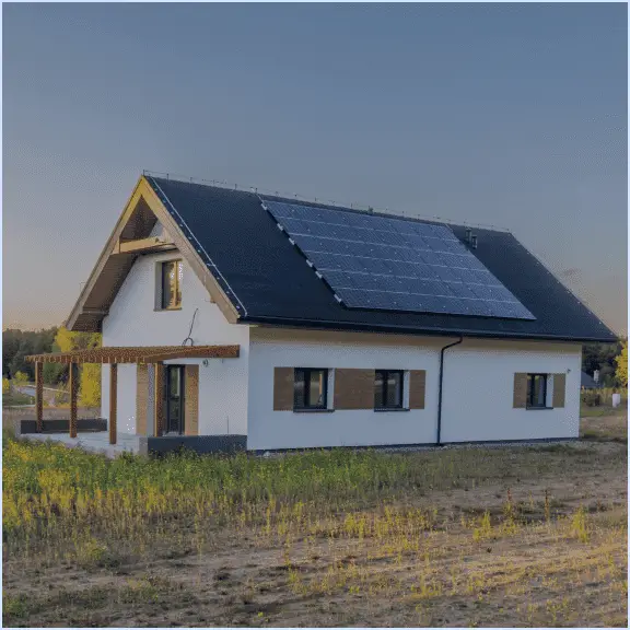 Maison moderne avec panneaux solaires installés sur le toit, située dans un environnement naturel.